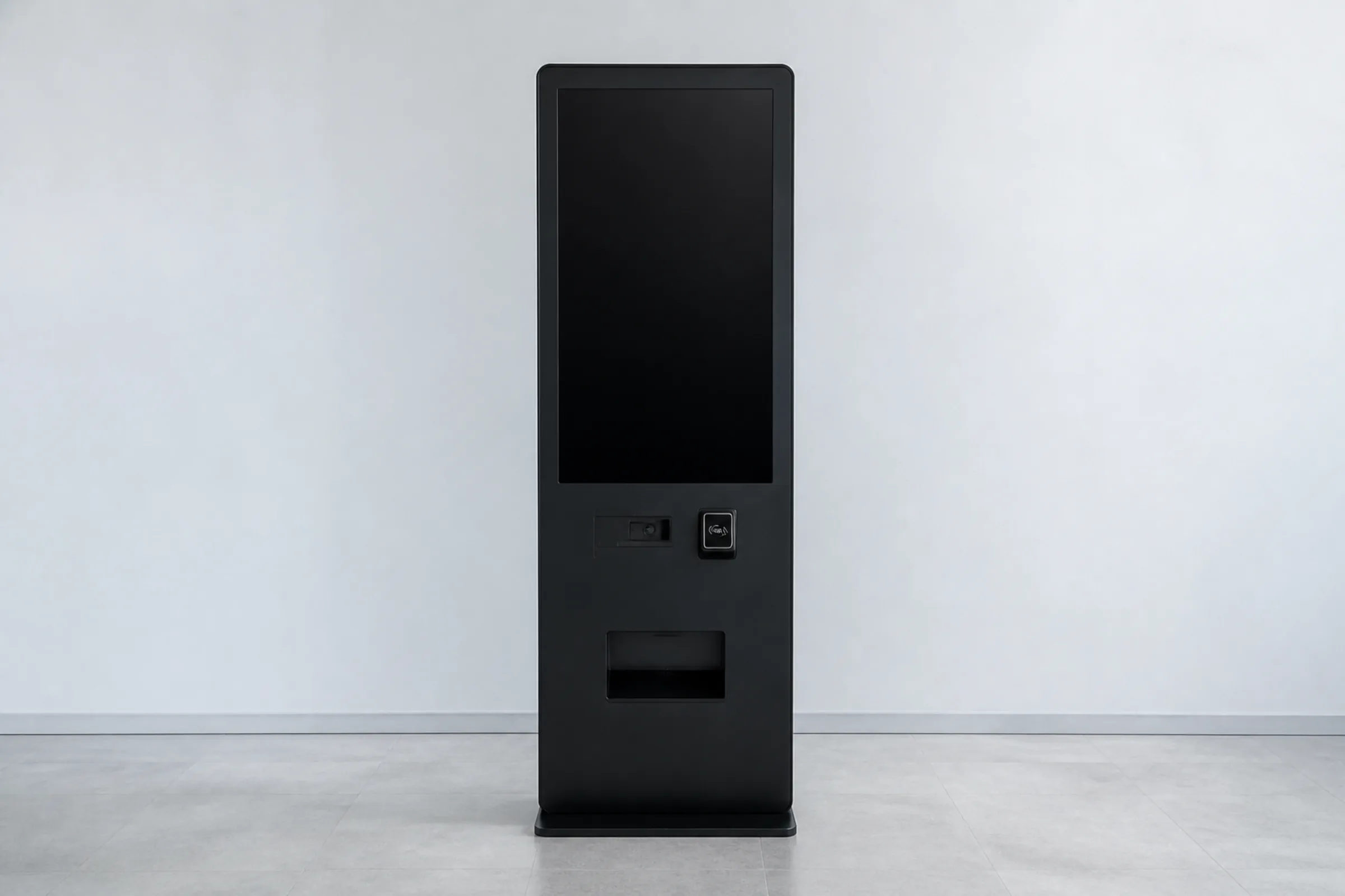 A vending kiosk photographed straight on with its touchscreen dark and blank, showing no product and no interface, against a plain pale wall.